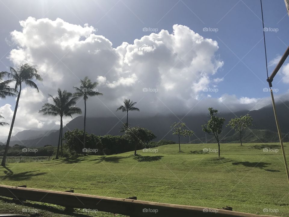 Mountains in Hawaii with clouds on top of them. 