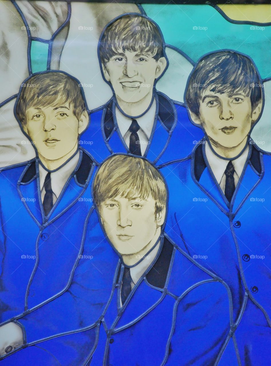 The Beatles in stained glass . A stained glass image of The Beatles in a window of The Hard Rock Cafe in Rome