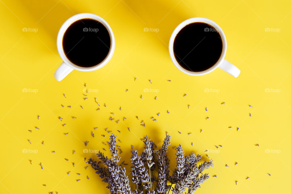 Business working morning with cup of hot coffee, sweet croissant, lavender flowers on yellow background close up. Top view, copy space, flat lay, mockup.