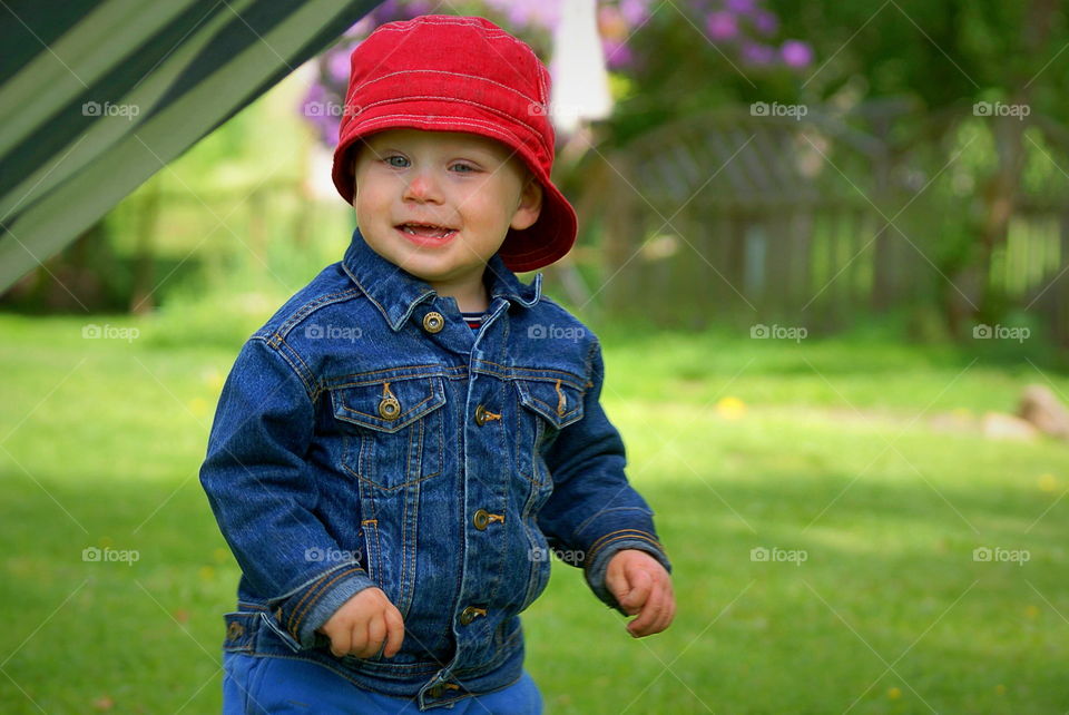 Happy toddler in red summer hat