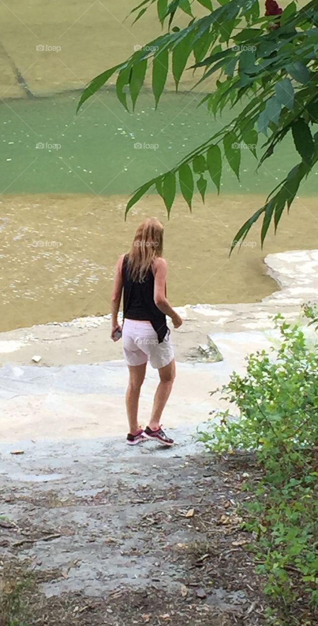 Young woman walking along the river.