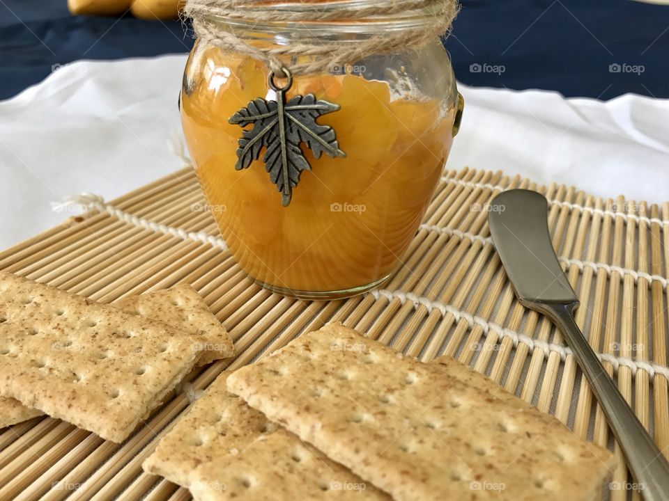 Mango jam with crackers on bamboo plate mat 