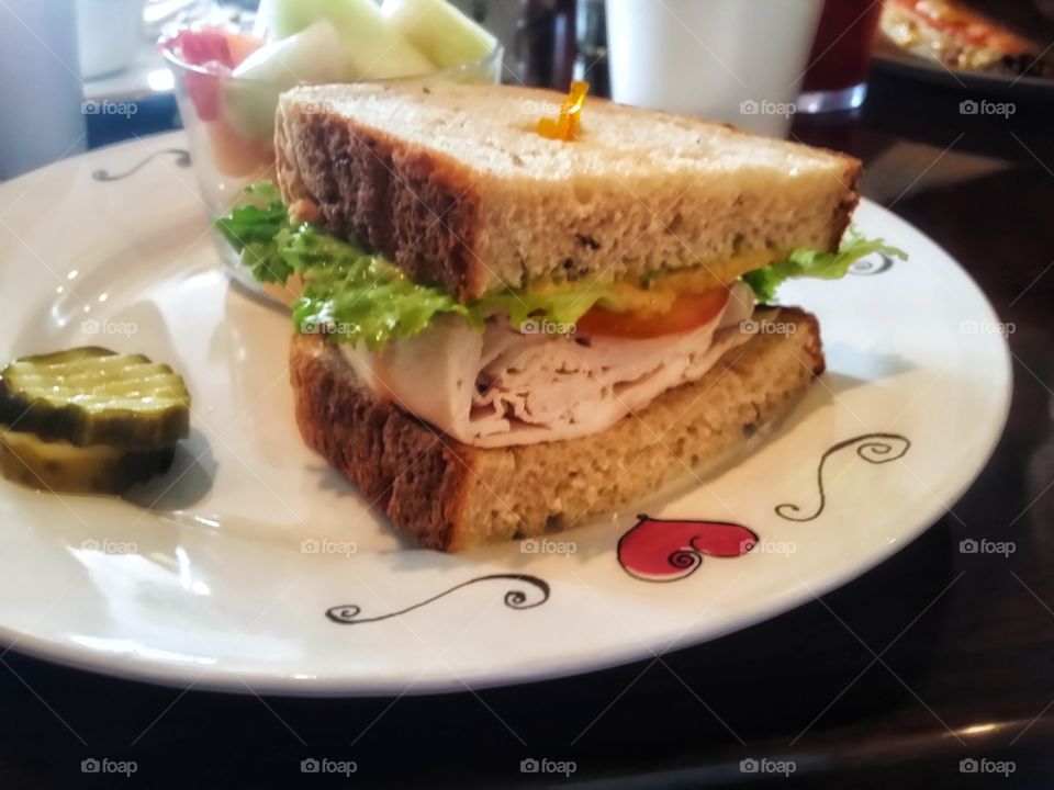 Turkey lettuce tomato Avacado dijon mustard on homemade rye bread with pickles and fruit on a heart plate my favorite sandwich