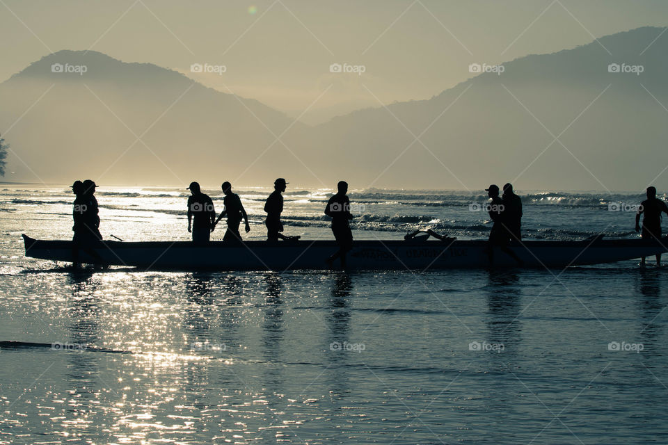 Trabalho em equipe de canoagem no nascer do sol lindo em praia do litoral norte no Brazil
