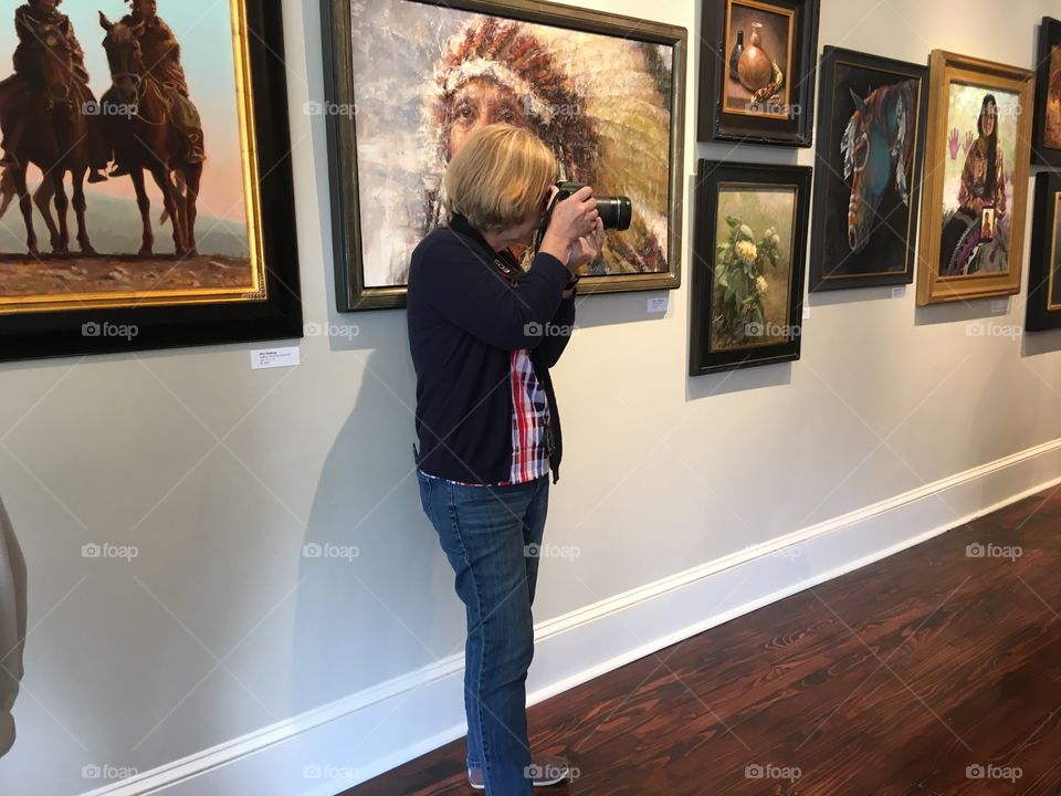 News paper photographer taking her own pictures of our group and paintings. 