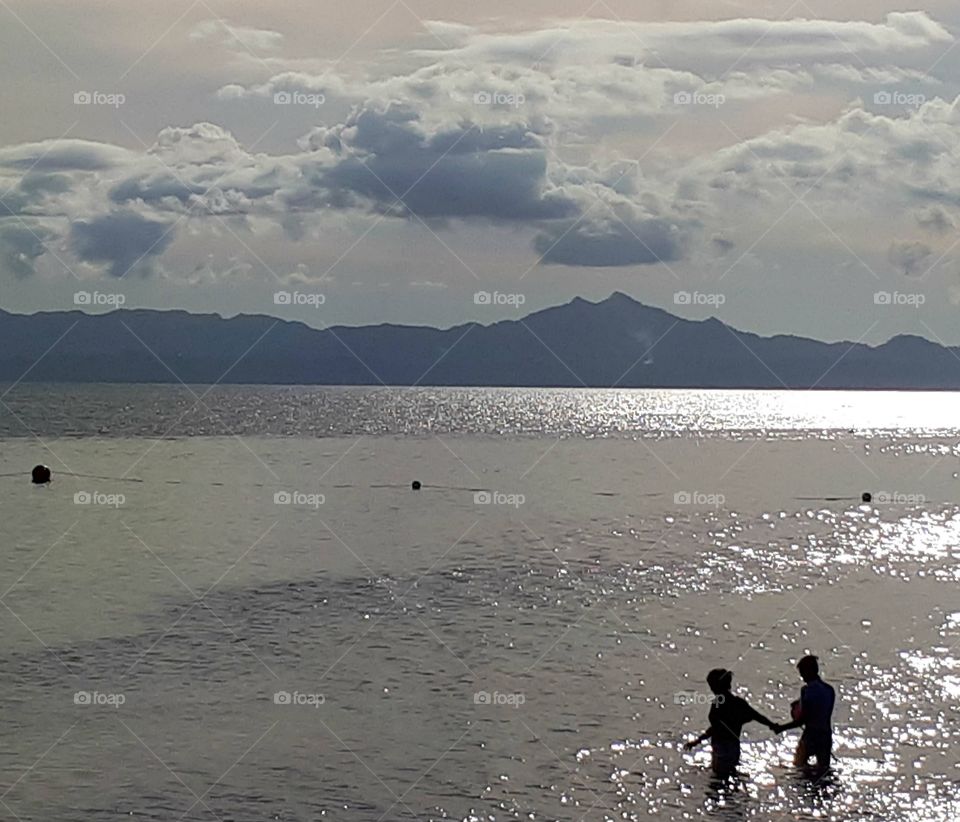 2 people  walking in the water