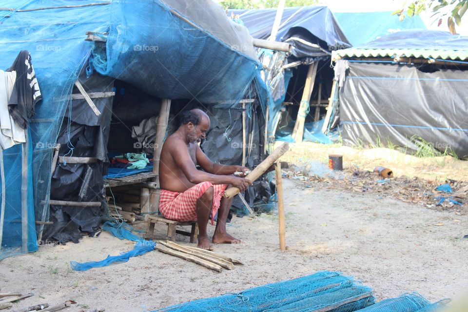 This picture was described about a fisherman putting bamboo to stitch the net.