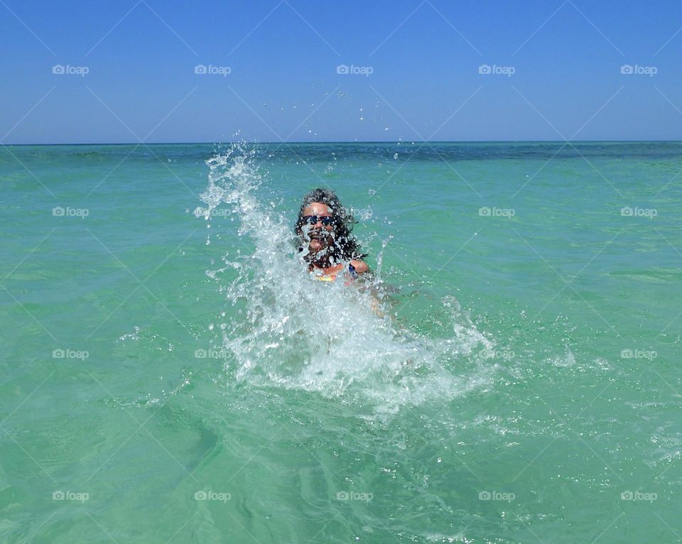 Summer is more fun actively splashing in the blue waters of a deserted tropical beach