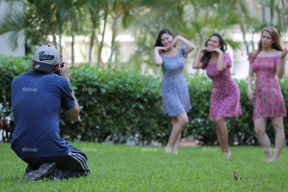 Male photographer photographing female friends