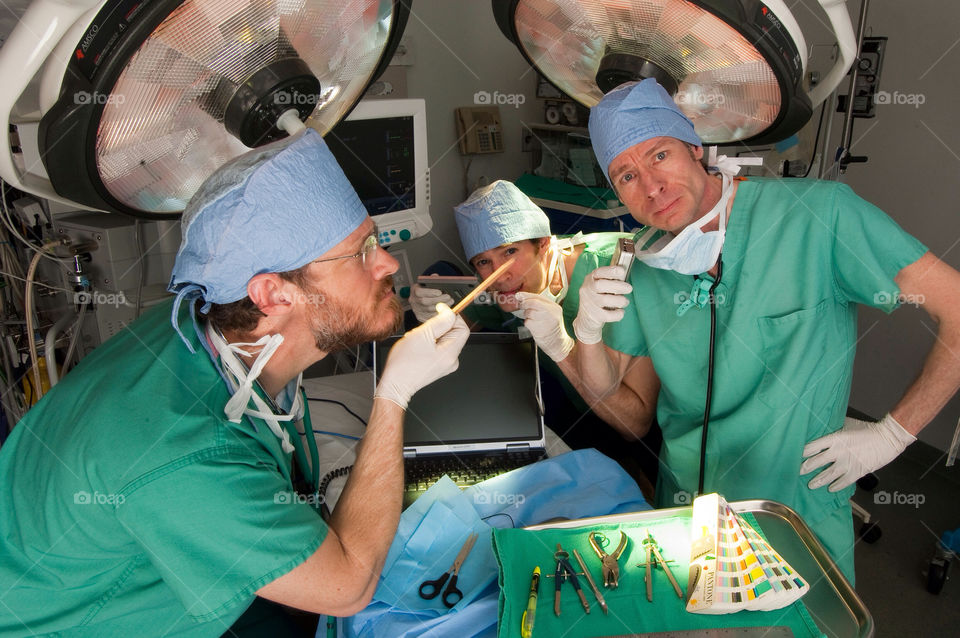 Three men operate on a computer on the surgical table in the emergency