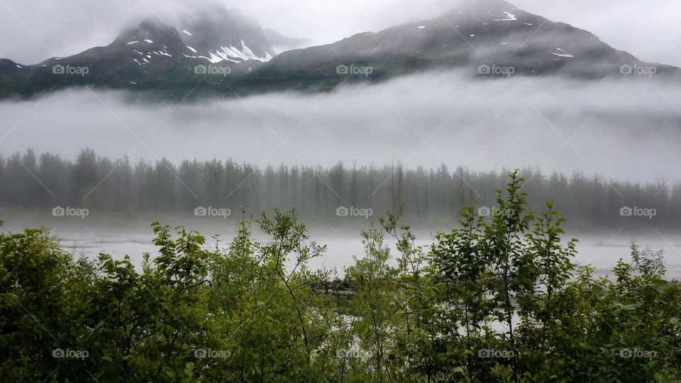 Chugash Mountains in the clouds, mist on the river. Alaska