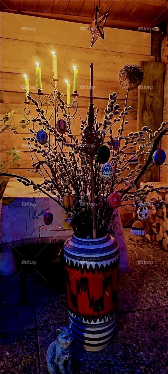 This is a special custom for “Easter”: goat willow twigs are arranged in a bouquet and decorated with hand painted eggs. In addition white candles are lit on a candelabra in this shed in rural “Bavaria”, Germany. 2024. Hypnotic Productions