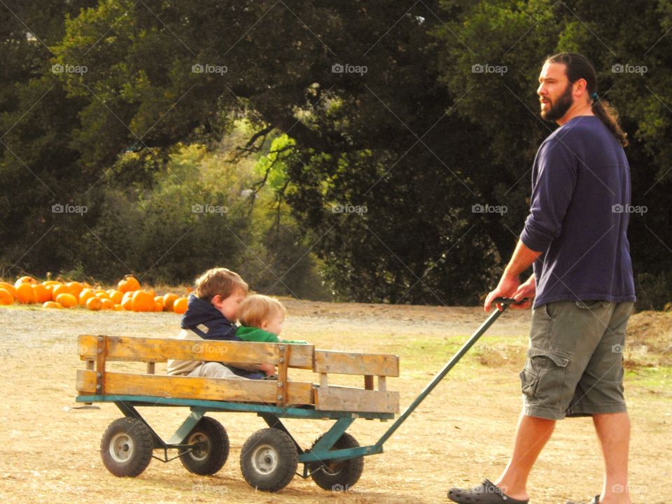 Dad Pulling Kids In A Wagon
