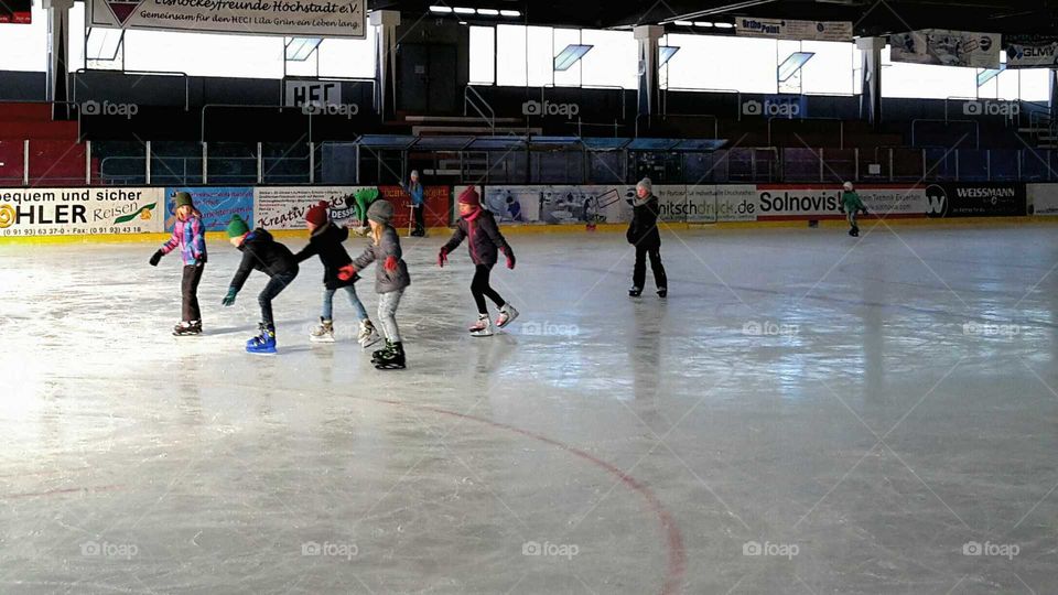 children skating in an ice stadium