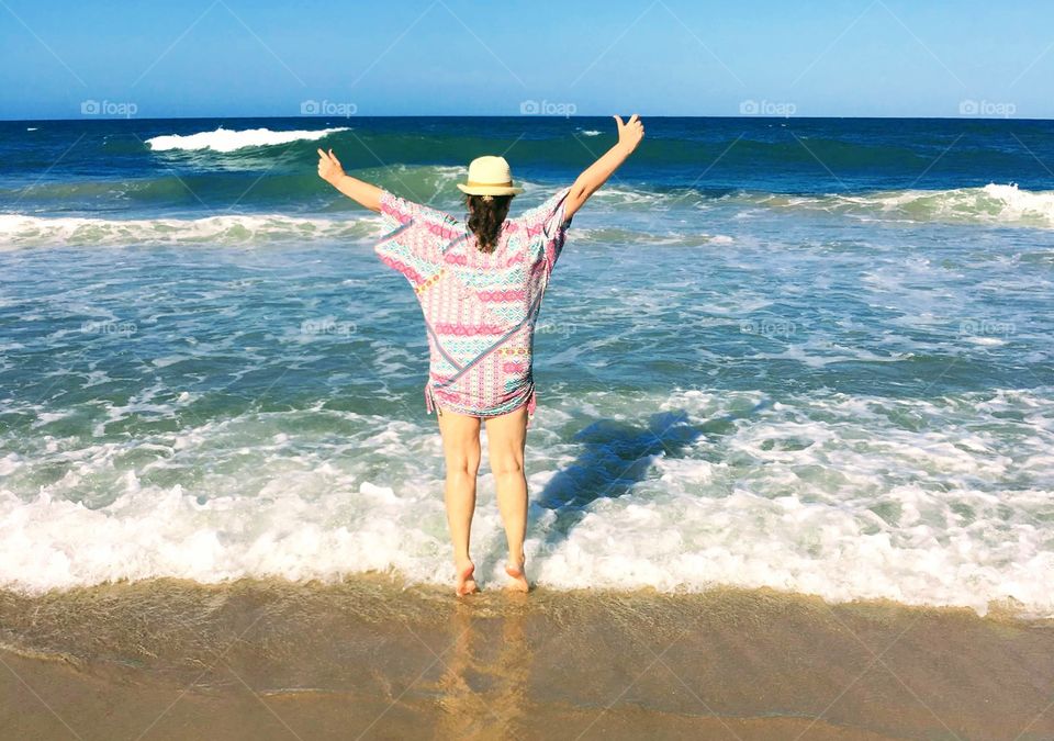 Woman having fun in front of the sea