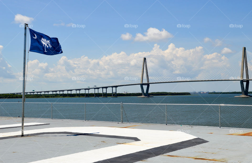 State flag of South Carolina next to the water and bridge