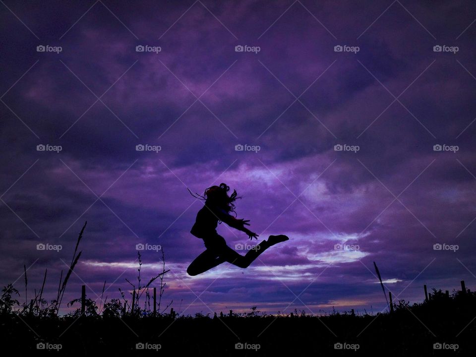 Jumping woman on sky background