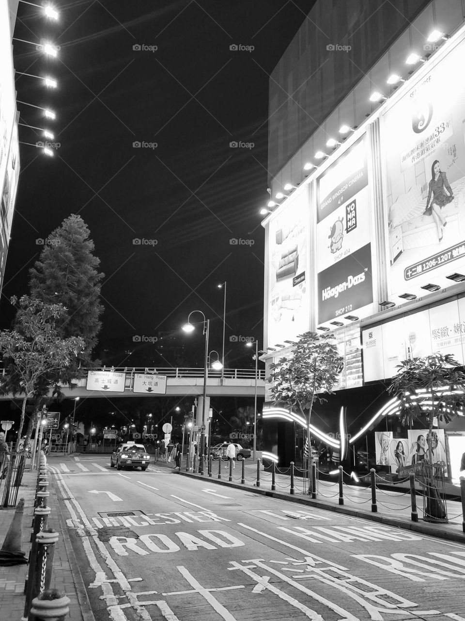 black and white photo of Causeway Bay,  outside of Windsor House in Hong Kong