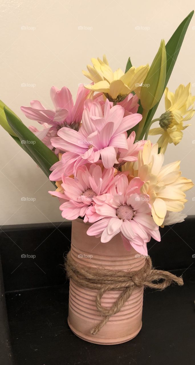 Pink tin can with daisy flowers tulips 