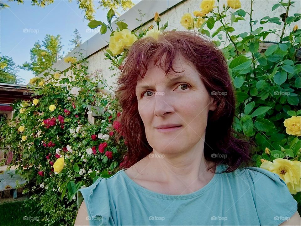 The lovely lady is the purveyor of the beautiful garden in rural „Lower Bavaria“, Germany. She tends to its many plants and adds decorative elements such as the rose bow and the garden sculptures. 2024. Hypnotic Productions