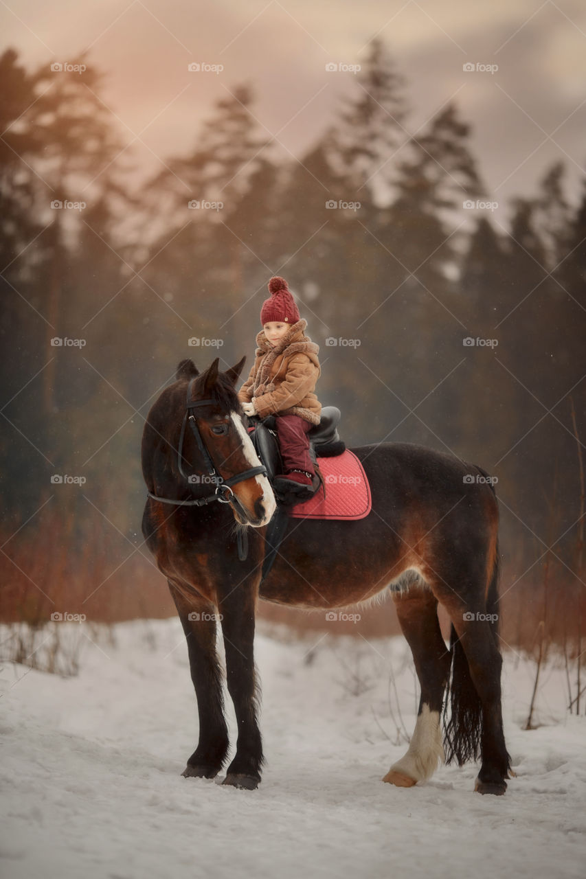 Little girl with horse outdoor portrait at spring day