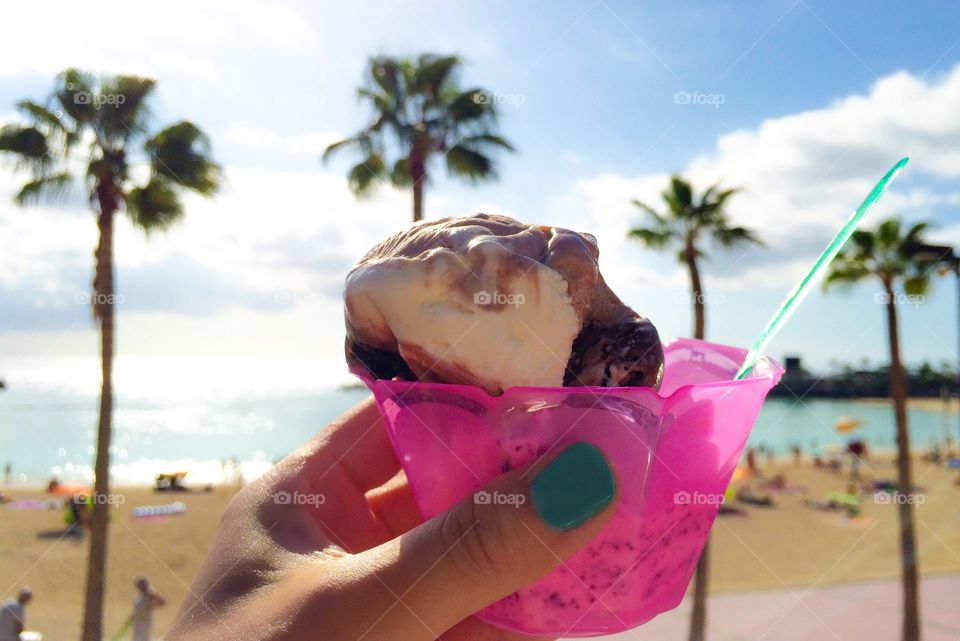 Woman hand holding ice cream on beach