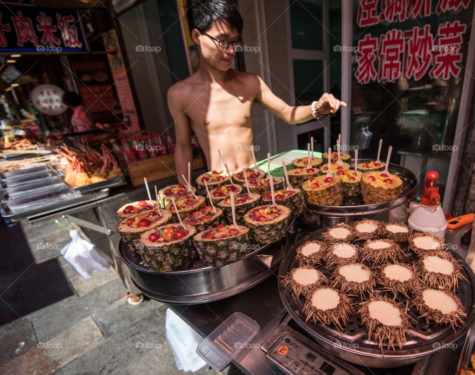 Asia, china streer food, sea food at street sellers in Qingdao pineapple with seafood