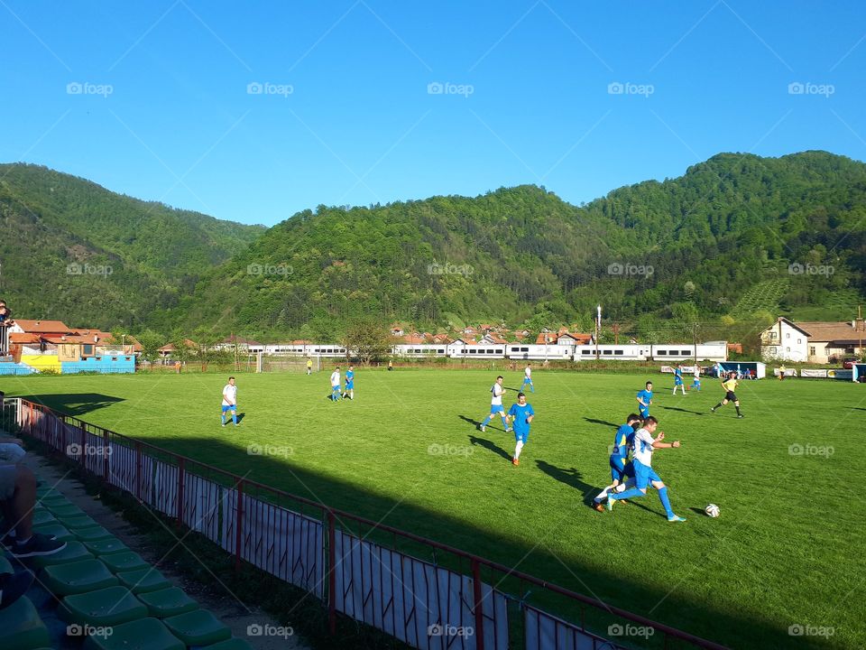 The train passes while a soccer match is in progress