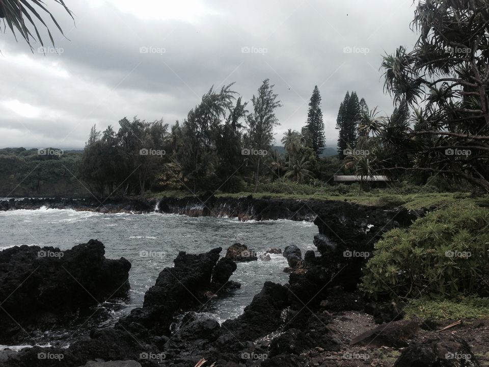 It's a cloudy day.
Pacific Ocean waves crashing against the coastline on the island of Maui 