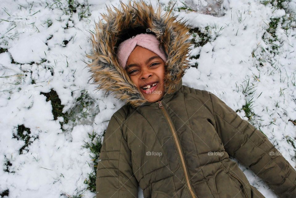 Smiling girl Lying in the snow 