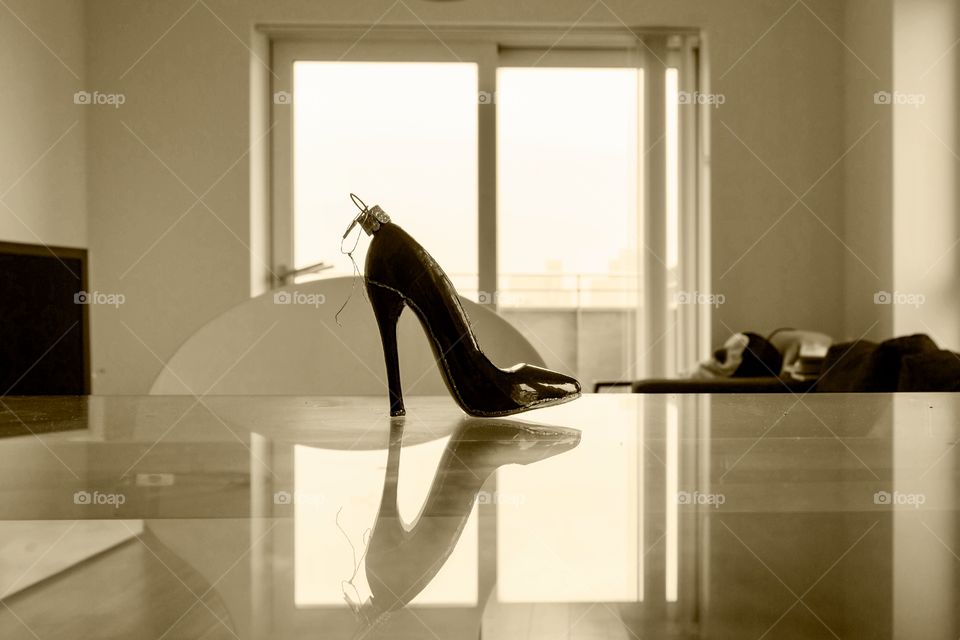 Hanging tree ornament shoe and reflection on the glass table in the room