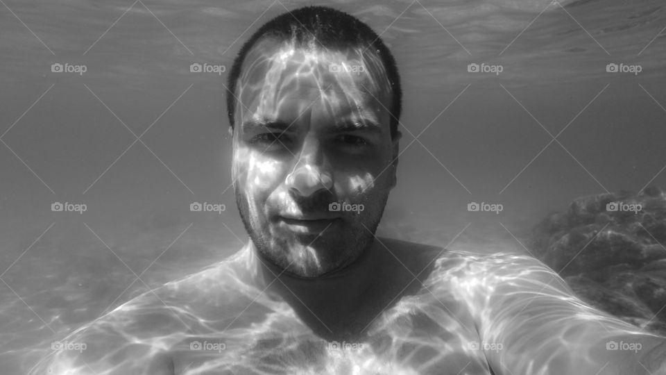 Shirtless man underwater in sea