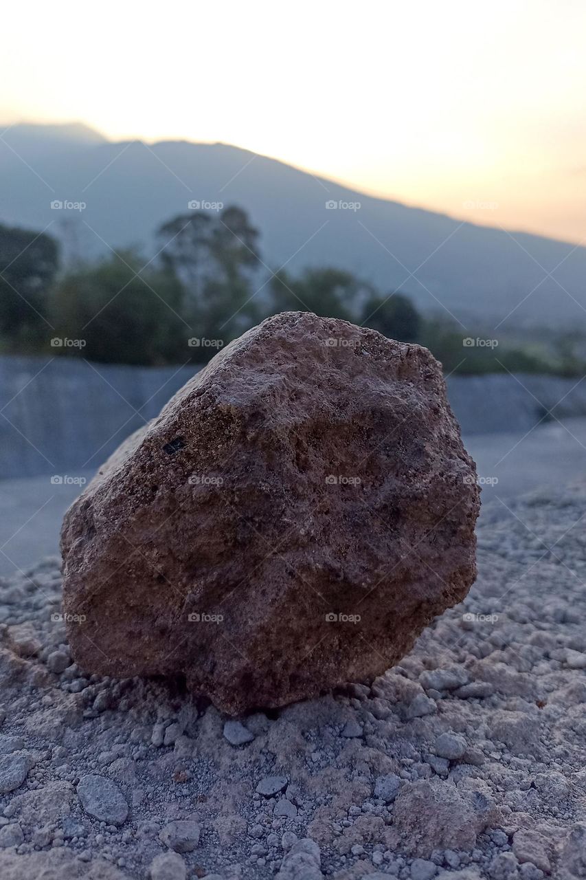 Close-up of rock on land against sky during sunset