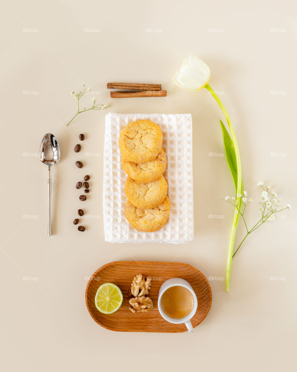 Eco friendly, morning, food composition with homemade citrus cookies, cup of espresso, coffee beans and tulip on a light background. Relaxing at home, handmade low carb baking, coffee time. Top view