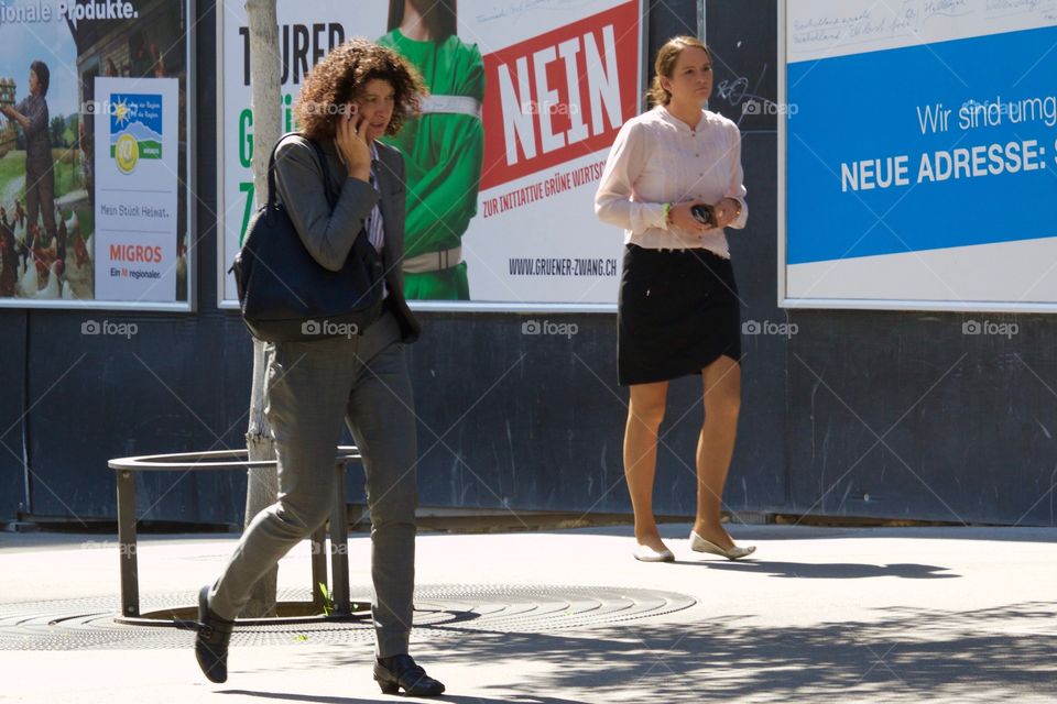 Business Woman Talking On Her Cell Phone While Walking Down The Street