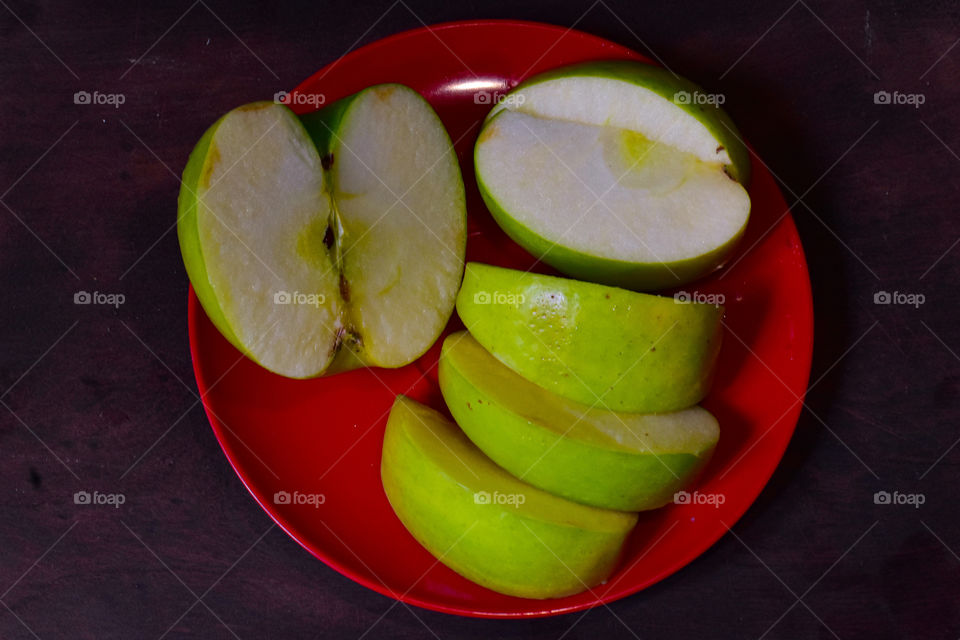 green apple on a red plate