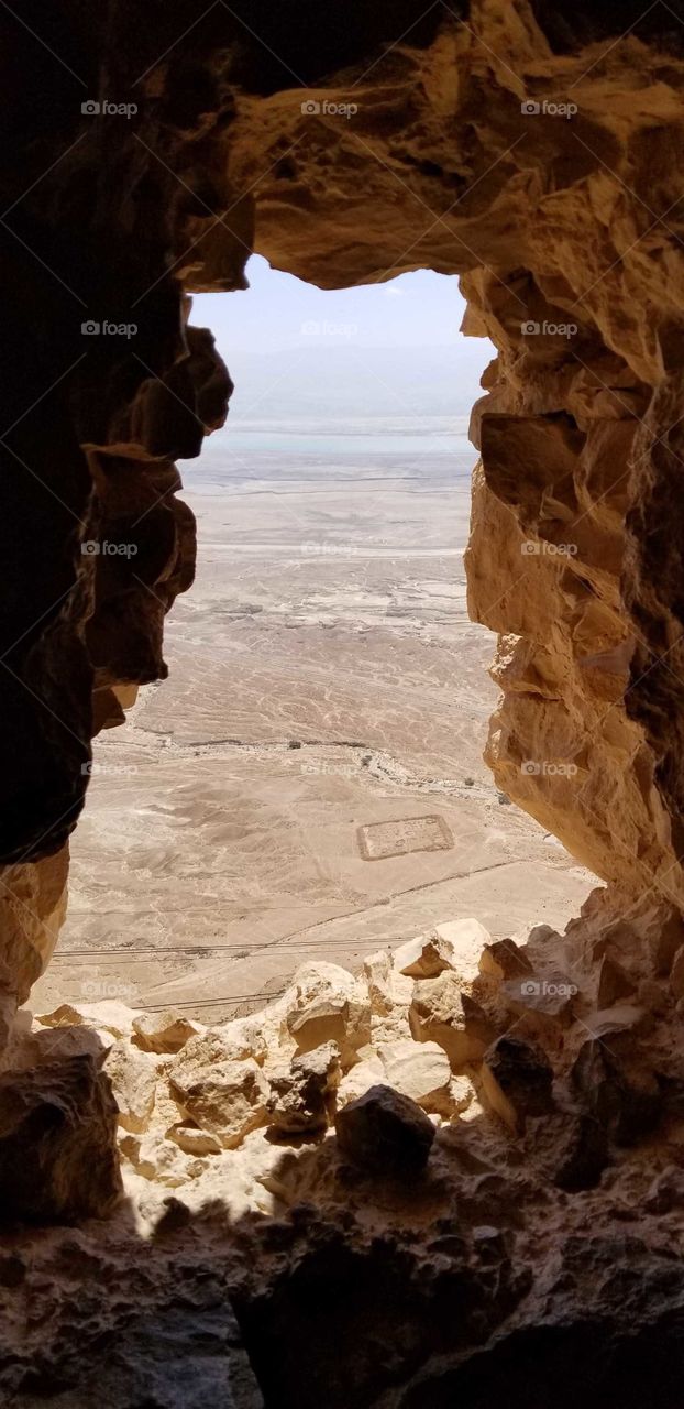 view of the ruins of a Roman camp from an archer's niche at Masada, Israel