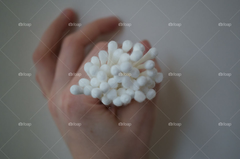 Bunch of cotton swabs close together, held by a hand representing the ring sign