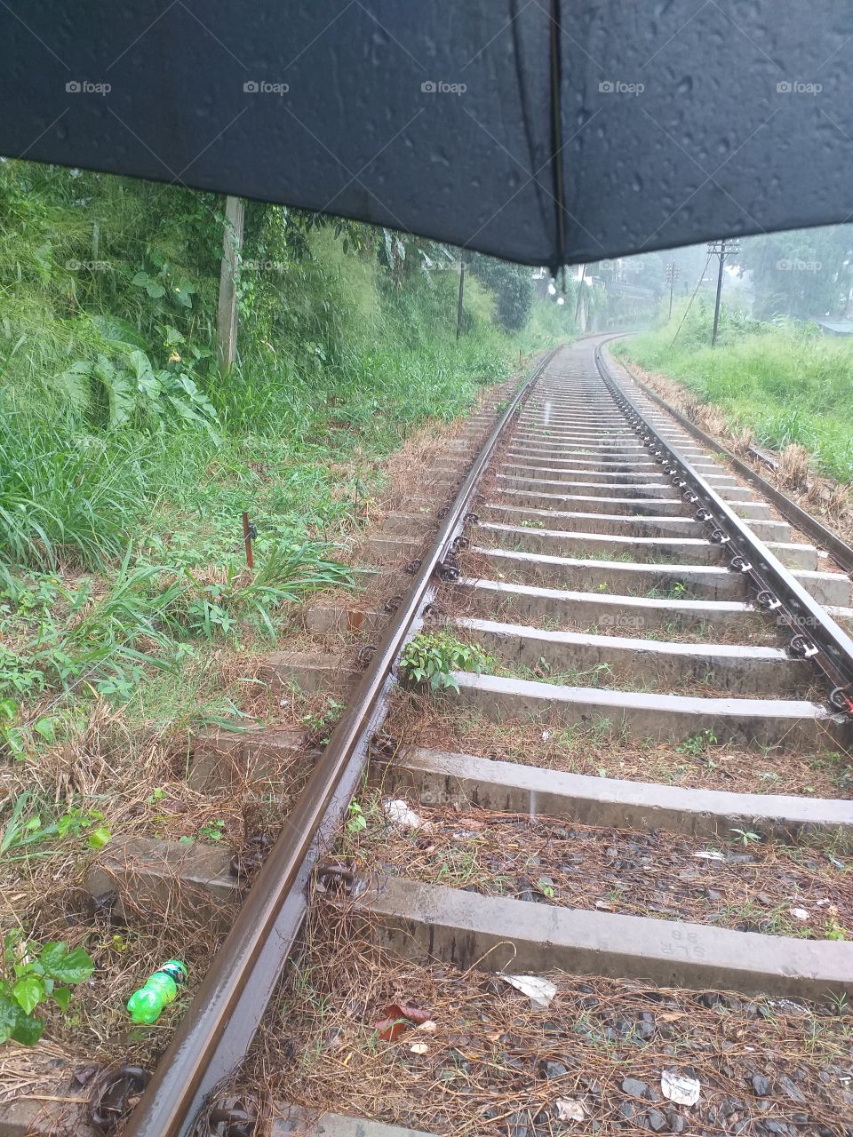 railway walking in rain with umbrella