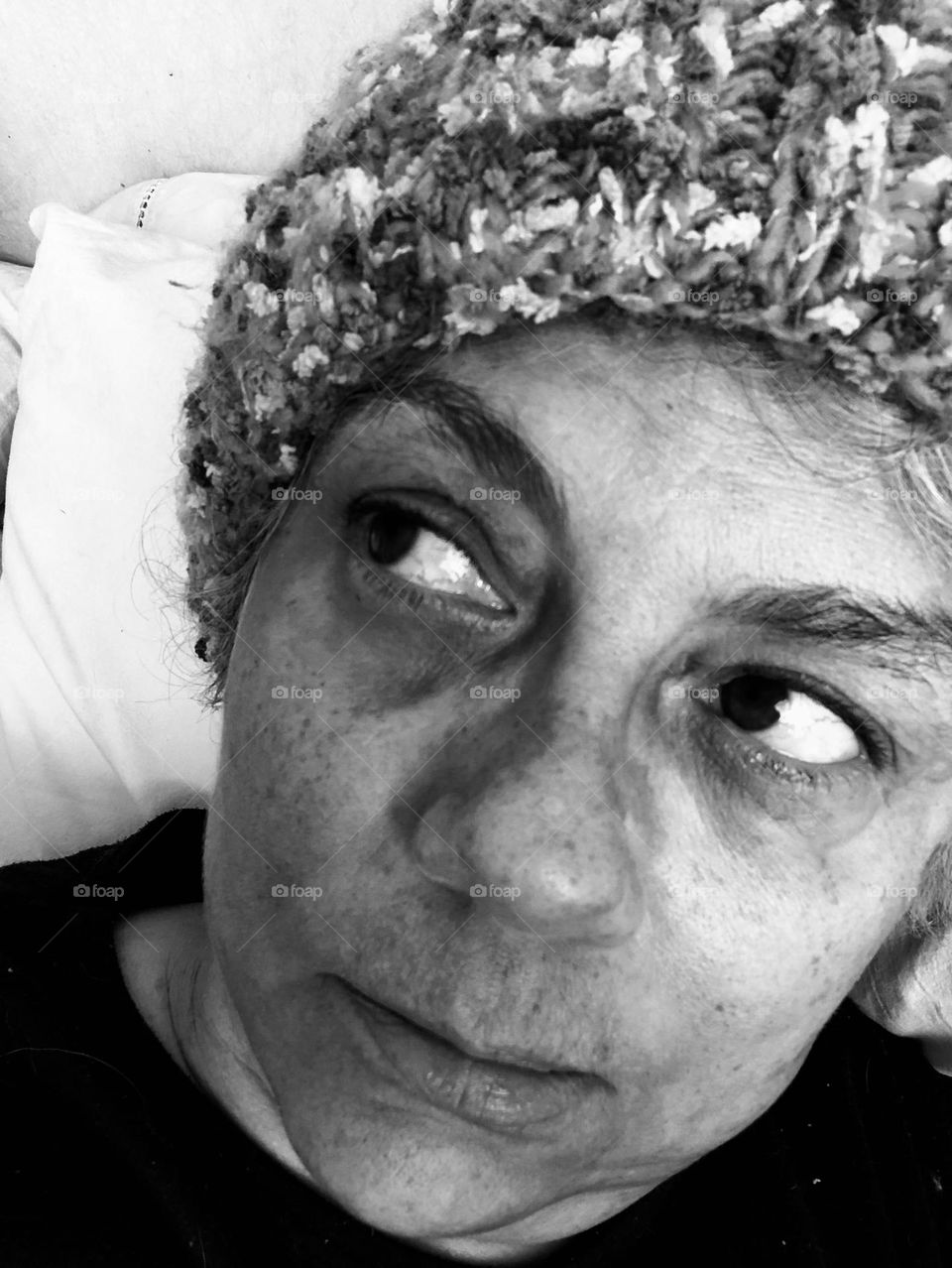 Woman in a wool hat shows her emotions for being stuck indoors during a particular cold winter weekend. 