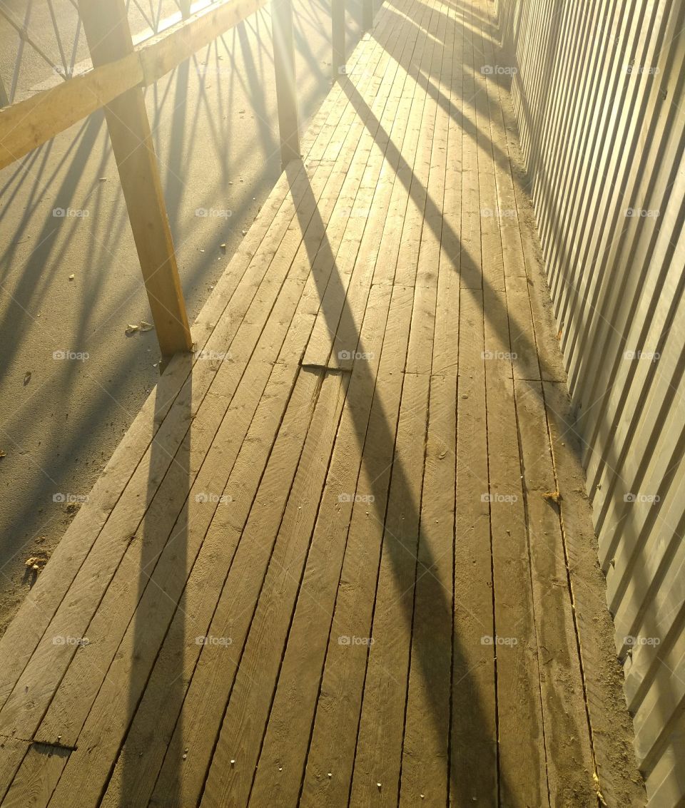 Sun and geometric shadows on the wooden pavement
