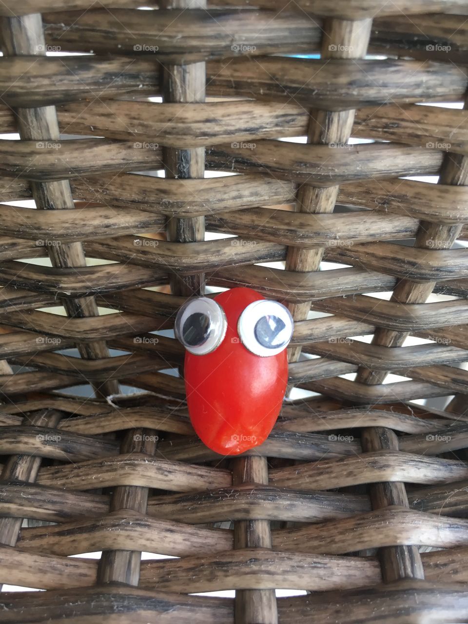 Miniature tomatoe with eyes on a brown chair 