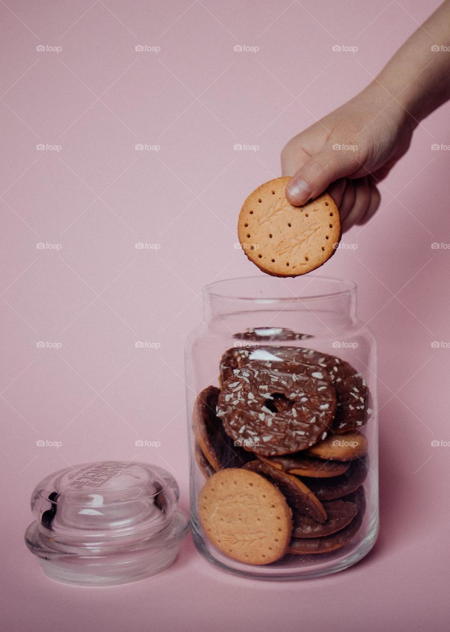 Cookie Jar with Child’s Hand on Pink Background