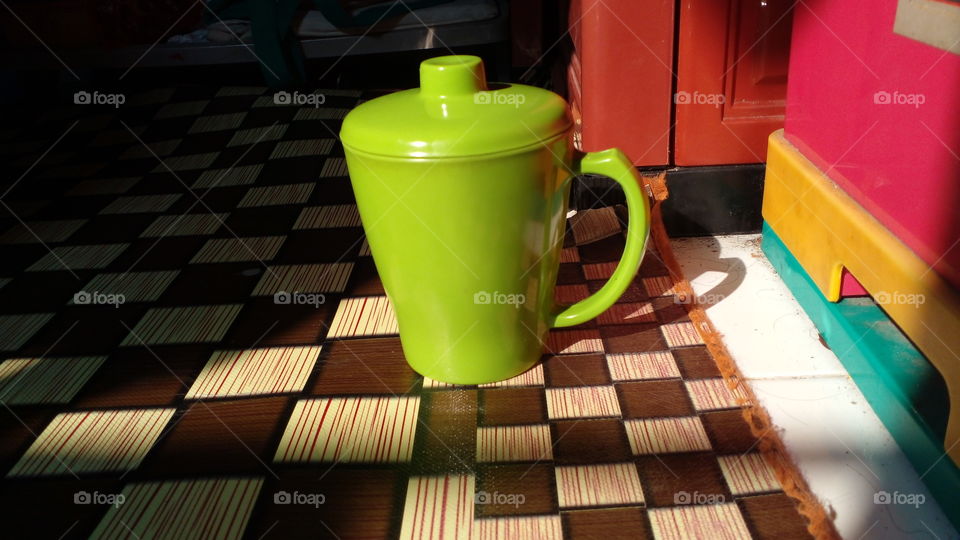 green mug under the light