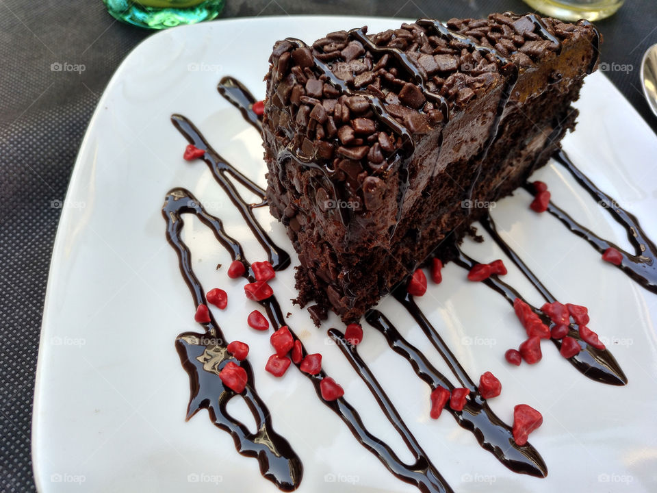 deliciosa tarta de chocolate con pepitas rojas sabor frutas del bosque y sirope de chocolate