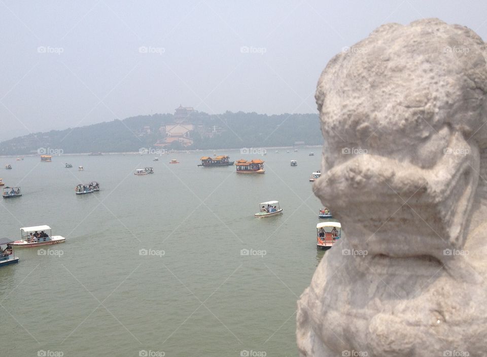 despite the pollution, seeing the boats coming and going to the summer palace, beijing, hinted at the rich ancient culture this place once saw