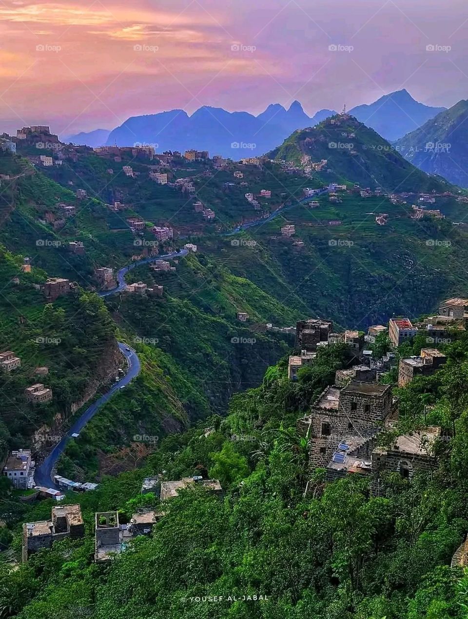 The image embodies a natural natural plate of the mountains of nature, where green agricultural stands are graded on the slopes as if they were lines of a poem, which fog harmoniously wrapped, and clouds hugged them in the mountain knife and the whis