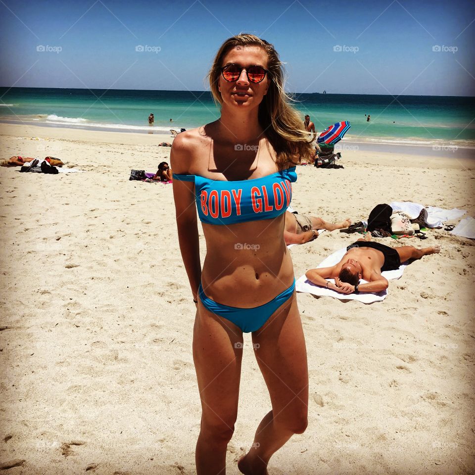 Fashionable woman in bikini standing at beach