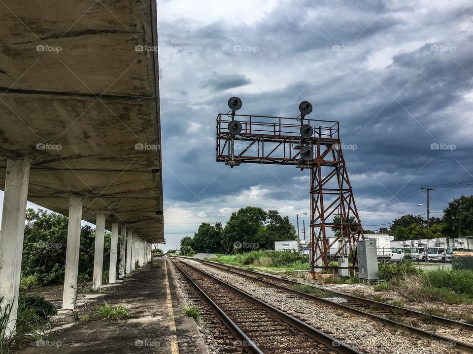A scene once sprawling with railroad activity, now reduced to concrete, grass, and signals