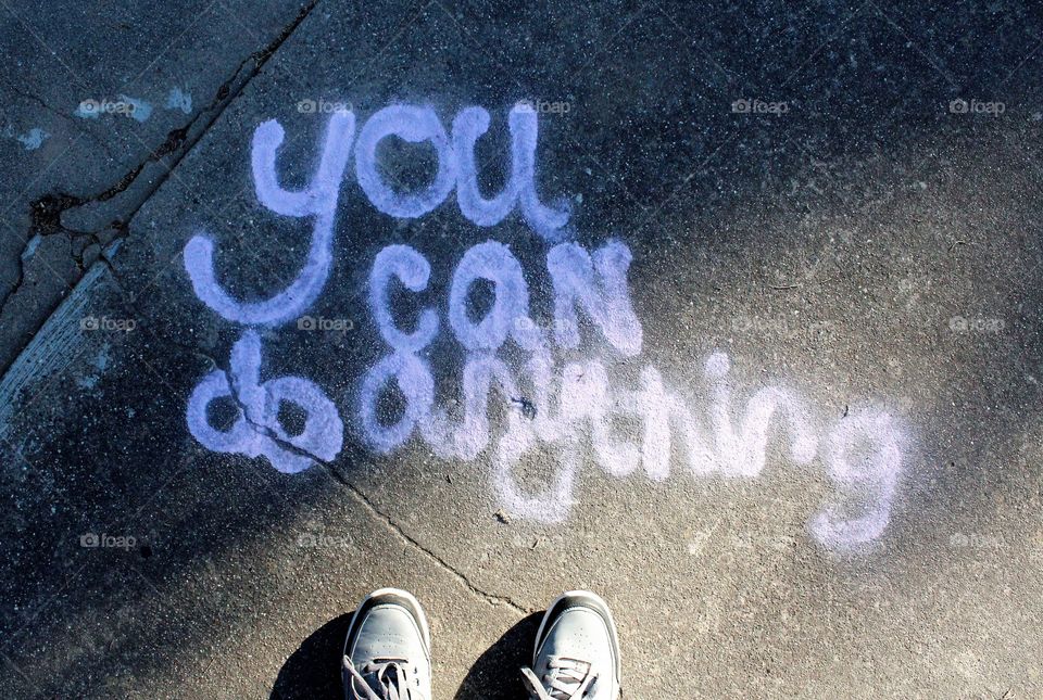 concrete. Message. Words. shoes. standing in front of an encouraging message.